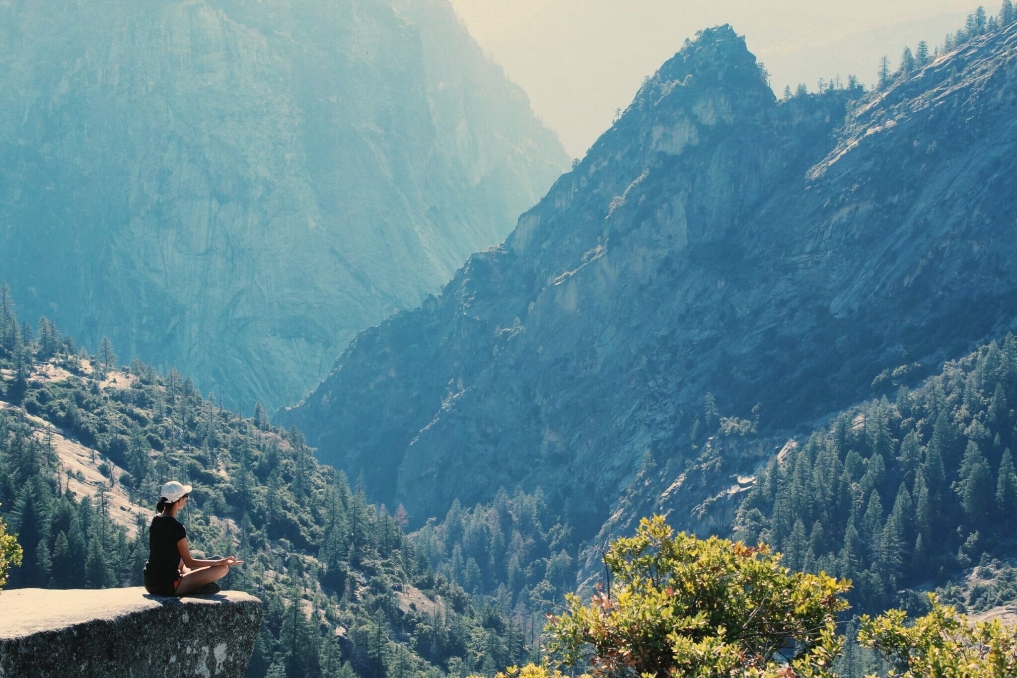 woman meditating on cliff face