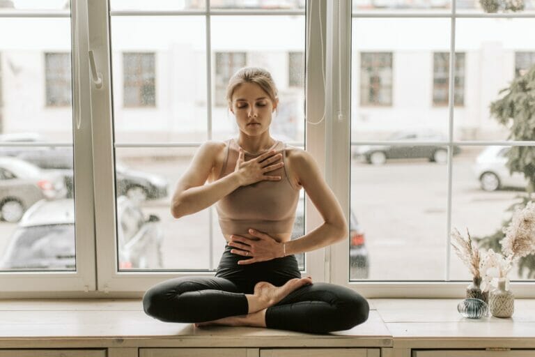 woman doing yoga in front of windows